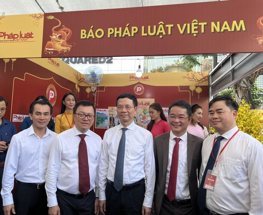 Bộ trưởng Bộ Thông tin và Truyền thông Nguyễn Mạnh Hùng (thứ 3 từ trái sang) cùng Tổng Biên tập Báo Nhân dân, Chủ tịch Hội Nhà báo Việt Nam Lê Quốc Minh (thứ 2 từ trái sang) và Tổng biên tập báo Pháp luật Việt Nam Vũ Hoài Nam (thứ 4 từ trái sang) chụp hình tại gian hàng trưng bày của báo Pháp luật Việt Nam.