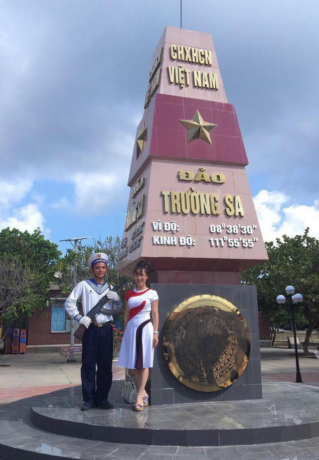 Bên cạnh cột mốc Trường Sa với bộ váy đi đường và đôi dép xăng đan.