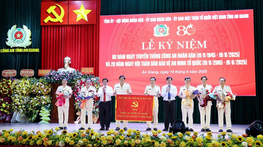 Đồng chí Nguyễn Tiến Hải, Bí thư Tỉnh uỷ và đồng chí Hồ Văn Mừng, Chủ tịch UBND tỉnh trao bức trướng và hoa tặng Ban Giám đốc Công an tỉnh An Giang.