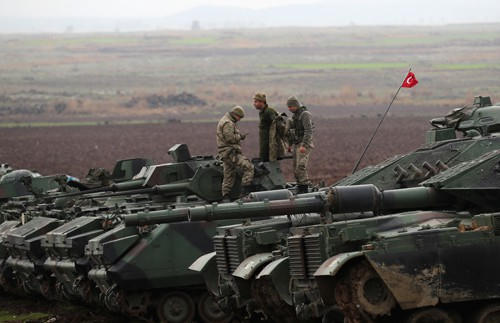 Binh sĩ, xe tăng và xe bọc thép chở quân của Thổ Nhĩ Kỳ tập trung tại biên giới với Syria hôm 23-1 Ảnh: REUTERS