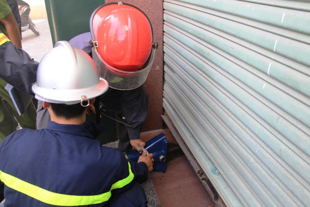 Lực lượng chữa cháy phải dùng máy nâng thủy lực mở cửa cuốn.