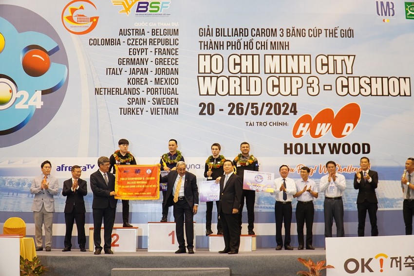 Ông Nguyễn Minh - Phó Chủ tịch UBND tỉnh Bình Thuận (bìa trái) tiếp nhận cờ đăng cai từ ông Farouk Barki - Chủ tịch Liên đoàn Billard Carom Thế giới (UMB). Ảnh: Quang Nhân.