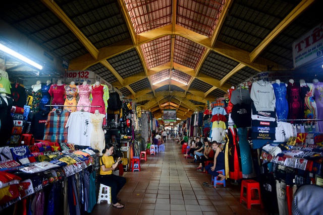 Vắng khách, các tiểu thương ngồi xếp hàng ngồi bấm điện thoại,