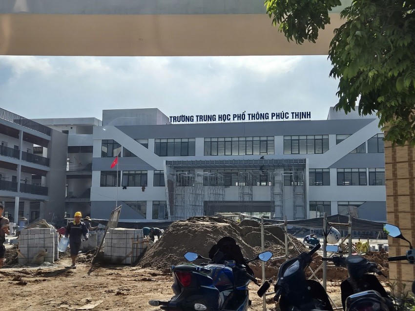 Gạch lát nền sân trường, xi cát, đất được gom đống ngay lối vào cổng chính của Trường THPT Phúc Thịnh.