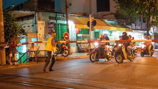 Nhiều người tham gia giao thông cố tình vượt ràu chắn khi tàu sắp tới  nên anh Tuấn phải đứng ra giữa đường điều tiết giao thông. 