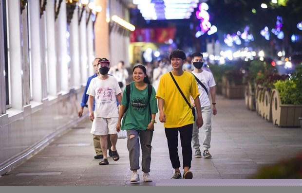 Các bạn trẻ thích thú với không khí trên phố đi bộ hồ Hoàn Kiếm ngày hoạt động trở lại sau thời gian tạm dừng hoạt động vì COVID-19. (Ảnh: Thành Đạt/TTXVN)