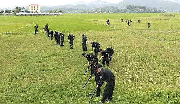 Cảnh sát lật từng bụi cỏ tìm súng và lựu đạn quanh vị trị chiếc xe các đối tượng cố thủ