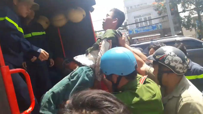 Lực lượng chức năng khống chế, đưa nam thanh niên xuống đất an toàn.