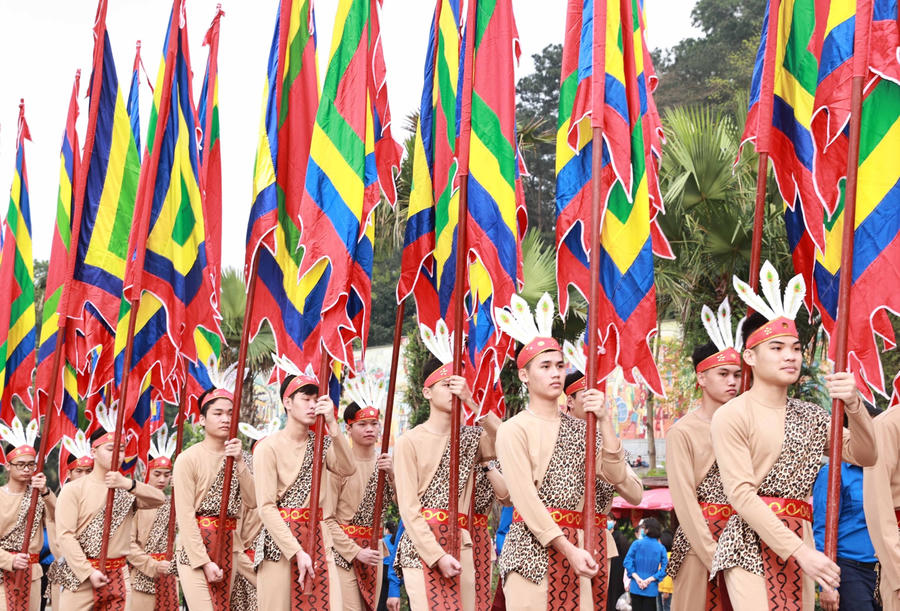 100 thanh niên tượng trưng cho con Lạc, cháu Hồng trong trang phục cổ, tay giương cao cờ hội, thể hiện sức sống mãnh liệt của dòng giống Tiên Rồng. (Ảnh: Thống Nhất/TTXVN)