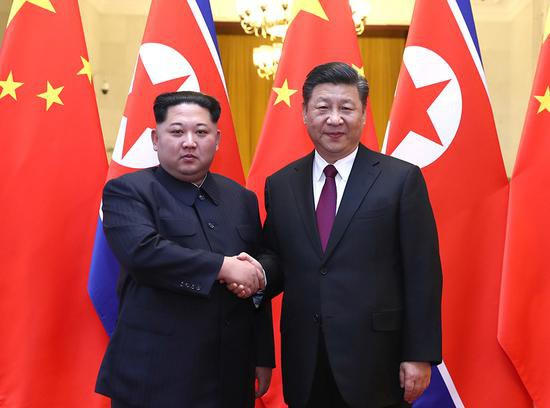Nhà lãnh đạo Triều Tiên Kim Jong-un bắt tay Chủ tịch Trung Quốc Tập Cận Bình tại Bắc Kinh (Ảnh: Xinhua)