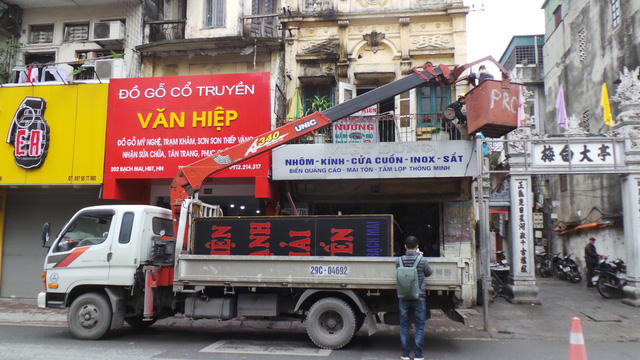 Phường Cầu Dền (Hai Bà Trưng) điều động xe cẩu để tháo dỡ bảng biển trên cao vi phạm.