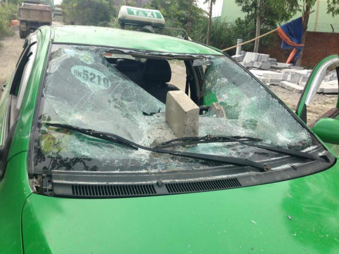 Xe taxi bị vỡ kính chắn gió phía trước và 2 kính cửa bên phải. Ảnh Facebook Tùng Lâm.