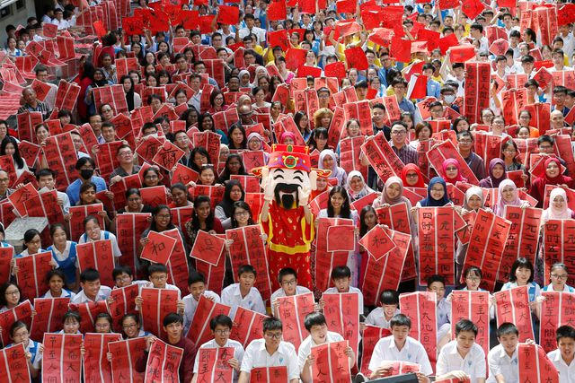 Các giáo viên và học sinh viết thư pháp tại một sự kiện chào mừng năm Kỷ Hợi tại trường phổ thông Tsun Jin ở Kuala Lumpur, Malaysia. (Ảnh: Reuters)