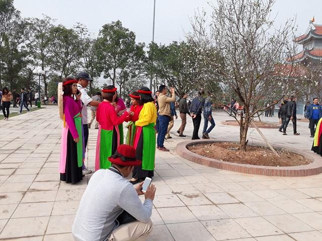 Du khách hào hứng chụp ảnh trong trang phục của các liền anh, liền chị.