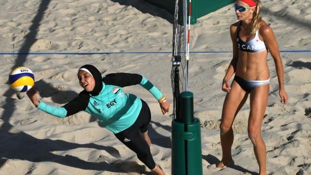 Hình ảnh cho thấy sự tương phản về văn hóa tại Olympic 2016. Trong ảnh là VĐV bóng chuyền bãi biển nữ của Ai Cập, Doaa Elghobashy (trái) đang thi đấu với bộ trang phục phủ kín người, thậm chí cả chiếc khăn trùm đầu.
