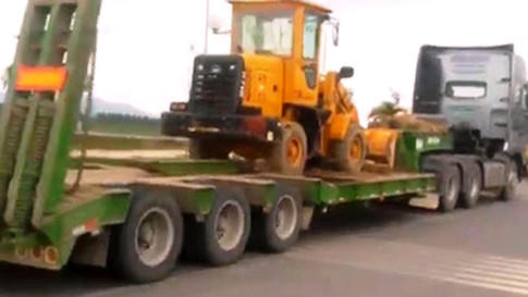 Chiếc xe đầo kéo chở theo máy ủi mini, gỗ, nhưng không hề có dây an toàn chằng buộc. (Ảnh: CSGT cung cấp).