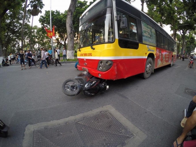 Xe máy chui vào gầm xe buýt.