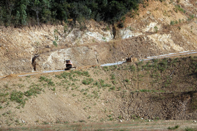 Đi theo con đường xuyên bãi đất dài gần hơn 100m mới đến con dốc thứ 2. Con đường chạy lên uốn lượn theo sườn núi. Cả một vạt rừng đã bị "cạo trọc" để làm đường.