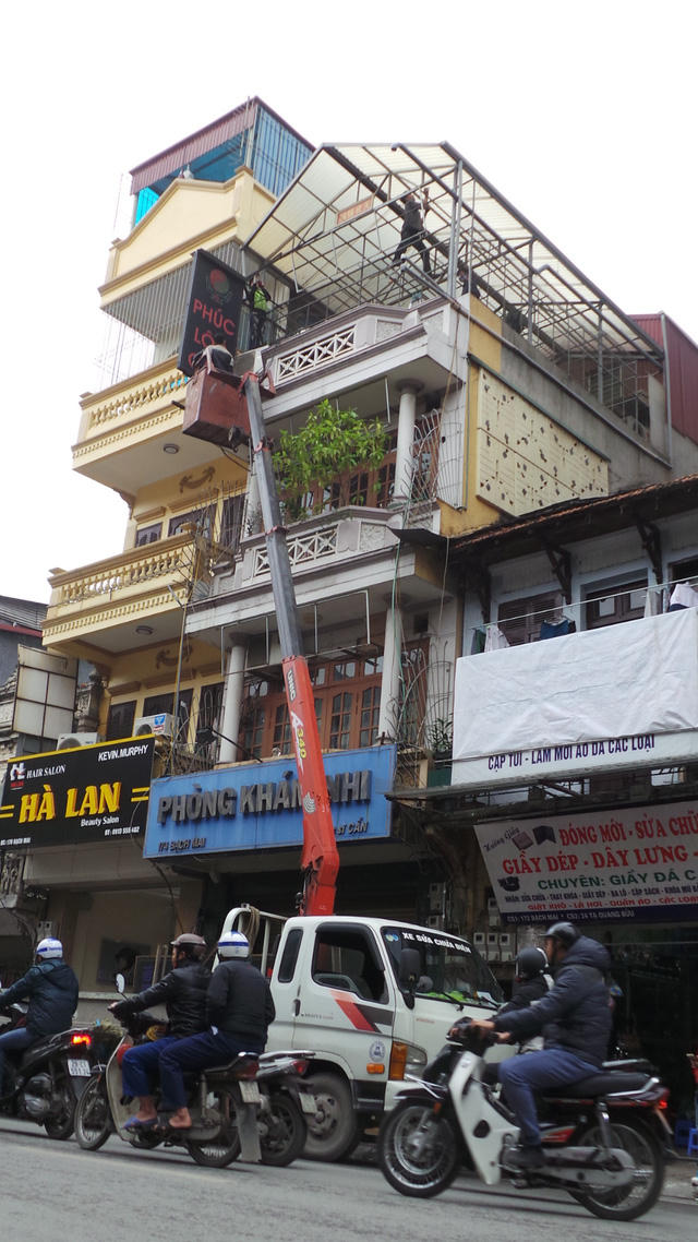 Biển hiệu trên tầng 4 và khung sắt dựng trái phép bị tháo dỡ.