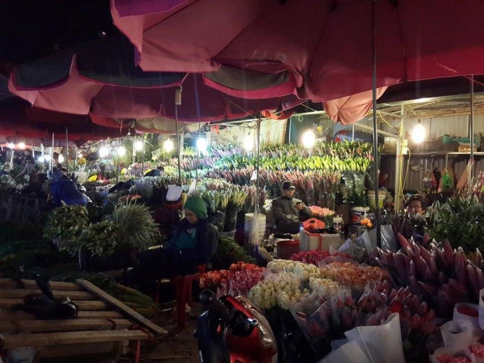 Chợ hoa rực rỡ và sáng bừng dưới ánh đèn.