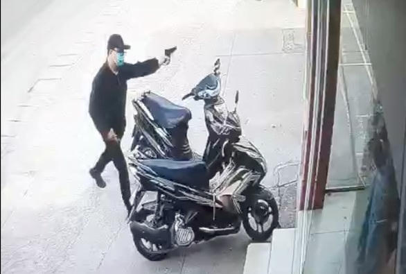 Nghi phạm dùng một vật giống súng uy hiếp bảo vệ ngân hàng rồi lên xe tẩu thoát.