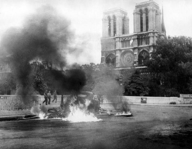 Xe bị đốt bên ngoài Nhà thờ Đức Bà Paris trong cuộc xung đột tại Pháp năm 1944. (Ảnh: AFP)