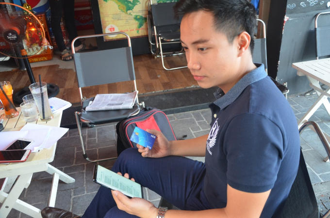 Anh Phúc cầm chiếc thẻ ATM mà mình bị một đối tượng từ Indonesia rút trộm mất hơn 38 triệu đồng.
