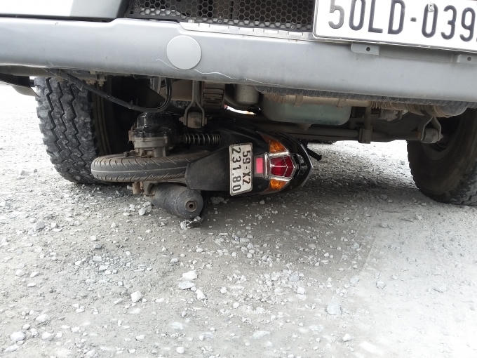 Chiếc xe m&aacute;y kẹt cứng dưới gầm container