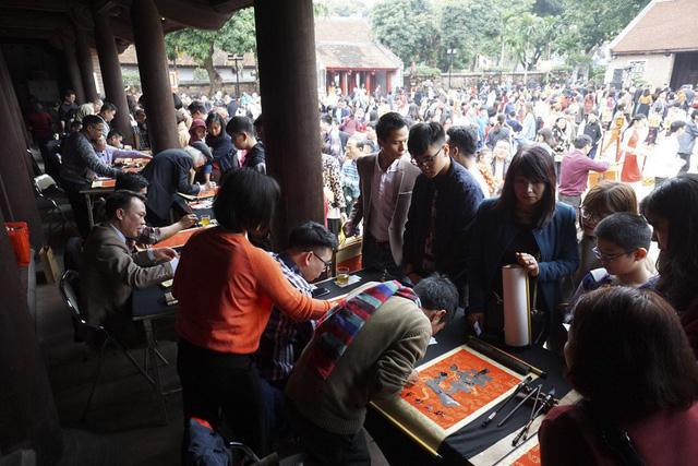 Trong sân Văn Miếu, rất đông người xếp hàng chờ xin chữ từ các ông đồ.