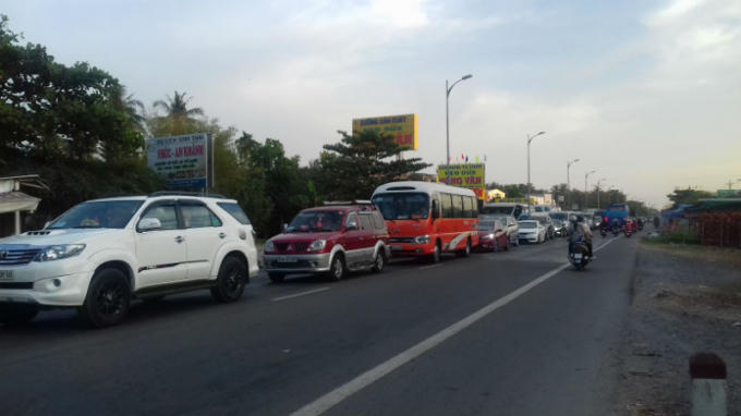 Một làn đường quốc lộ 60, hướng về Sài Gòn dày đặc xe ô tô, xe gắn máy; làn ngược lại thì...trống trơn.