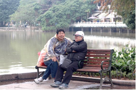 Trời không mưa nhưng cụ ông vẫn mặc áo mưa để giữ nhiệt cho cơ thể.