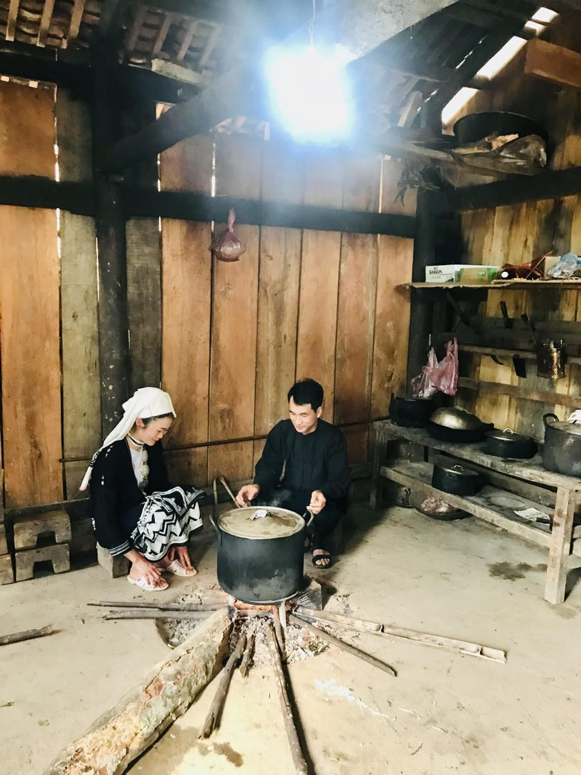 Vợ chồng anh Lý Hữu Nhất bên bếp lửa. (Ảnh: Thùy Dương)