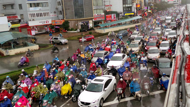 Dòng phương tiện dừng chờ đèn đỏ trong mưa rét ở Ngã tư Sở.