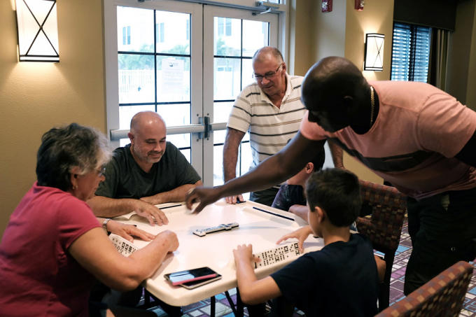 Một gia đình Florida ngồi chơi domino trong khách sạn giữa lúc bão ập vào. Ảnh: AFP.