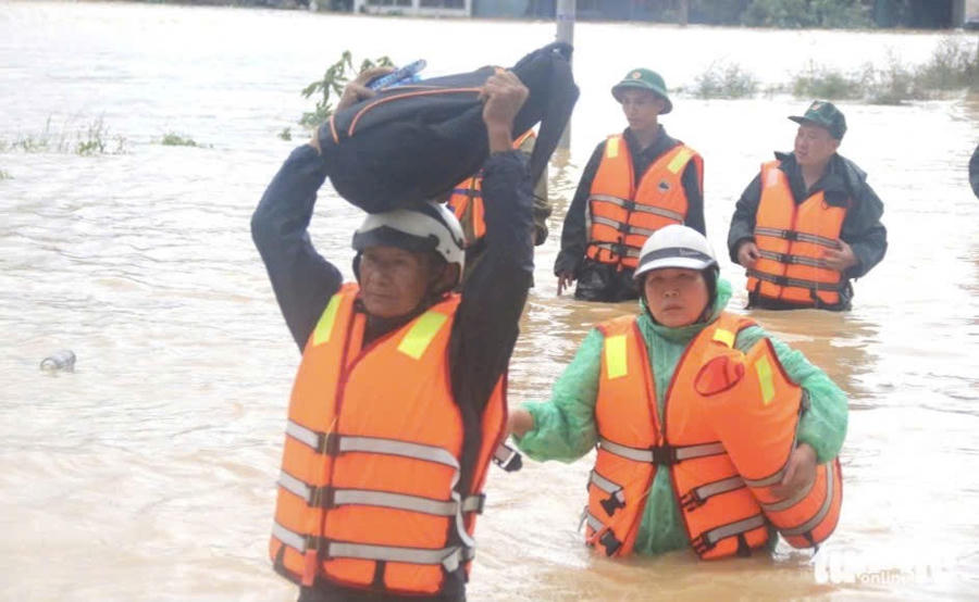 Lực lượng chức năng hỗ trợ người dân di rời người và tài sản đến nơi an toàn. Ảnh: T.H