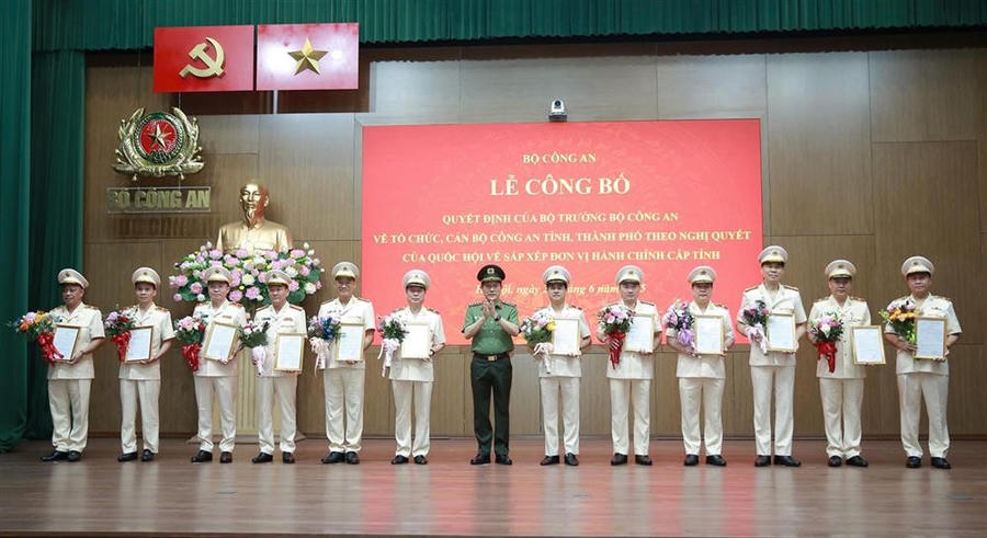 Bộ trưởng Lương Tam Quang trao Quyết định và tặng hoa chúc mừng 23 Giám đốc Công an địa phương sau sáp nhập.