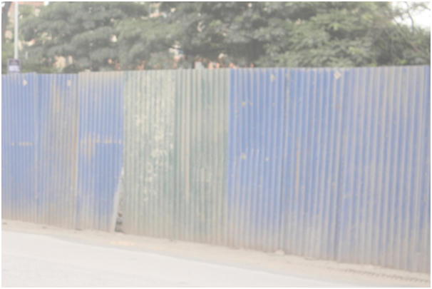 Những tấm t&ocirc;n chắn c&ocirc;ng tr&igrave;nh mở rộng đường vanh đai 3 Mai Dịch- cầu Thăng Long cũng bị bụi phủ trắng x&oacute;a.