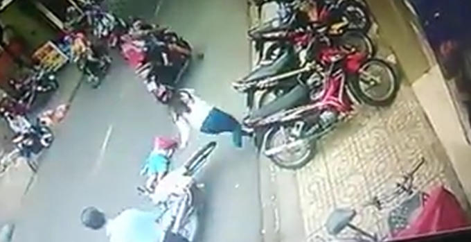 Cháu bé nằm bất tỉnh ngay sau khi bị xe máy chèn qua người.