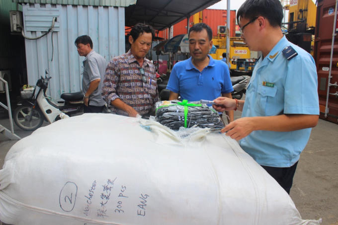 Cán bộ Đội 4 khám xét lô hàng giả nhập khẩu từ Trung Quốc. Ảnh: T.H.