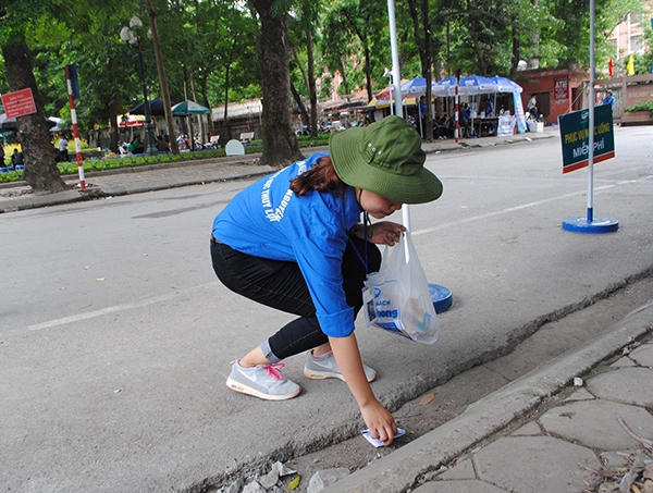 Sinh viên tình nguyện nhặt "phao thi" của thí sinh để chuẩn bị cho môn thi buổi chiều.