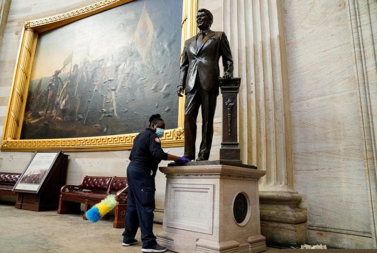 Nhân viên lau dọn bức tượng cựu Tổng thống Ronald Reagan bên trong phòng Rotunda của tòa nhà Quốc hội.