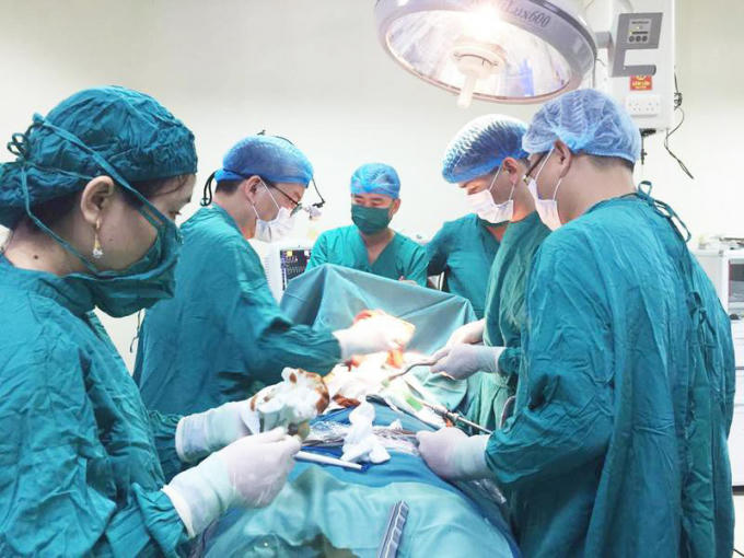 PGS. TS Nguyễn Hữu Ước - Trưởng khoa Phẫu thuật tim mạch - lồng ngực, Bệnh viện Hữu nghị Việt Đức cùng kíp bác sĩ BVĐK Hà Tĩnh thực hiện ca mổ nội soi. Ảnh: BVCC