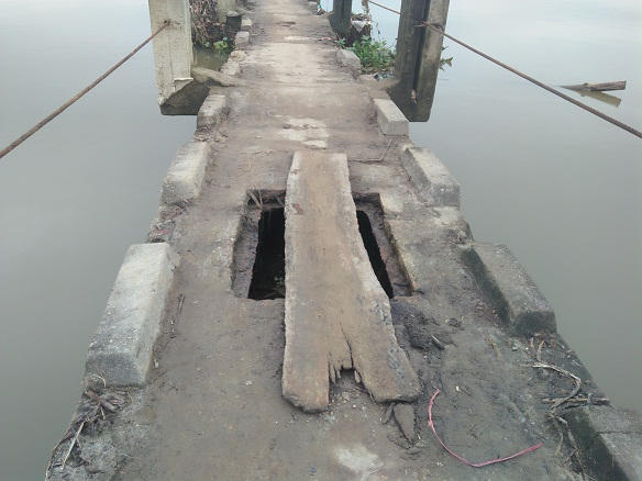 Ổ voi xuất hiện ngay trên mặt cầu, người dân lo sợ đến tính mạng nên lấy miếng gỗ vá lại.