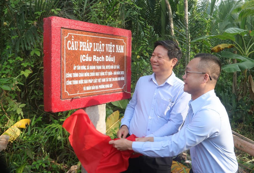 Ông Trần Thanh Lâm - Phó Bí thư Thường trực Tỉnh uỷ Bến Tre (trái) và Nhà báo Trần Ngọc Hà - Phó Tổng Biên tập Báo Pháp luật Việt Nam (phải) mở biển tên cầu.