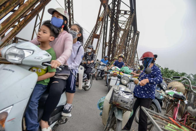 Dọc hai bên cầu có đến hơn chục điểm người dân họp chợ. Thỉnh thoảng những người chở hàng đến dừng đỗ, vận chuyển càng làm cho lối đi bị rối.