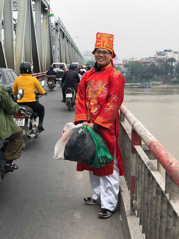 Một tình nguyện viên khu vực cầu Chương Dương với trang phục ông Táo, đang thu nhặt những chiếc túi nilon và rác trên cầu