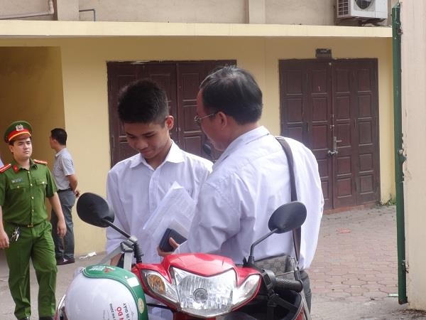 Hoàn thành bài thi của mình khá tốt, bạn thí sinh nam đã vui vẻ chia sẻ bài làm của mình với bố ngay khi ra khỏi phóng thi.