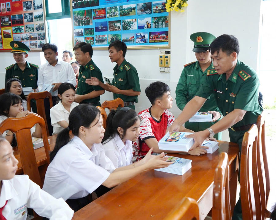 Cán bộ Đồn Biên phòng Đất Mũi tặng dụng cụ học tập cho học sinh.