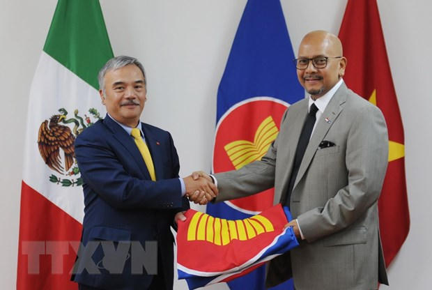 Đại sứ Việt Nam Nguyễn Hoài Dương trao cờ ASEAN cho Đại sứ Indonesia Cosmas Cheppy Tri Prakoso Wartono. (Ảnh: Việt Hùng/TTXVN)