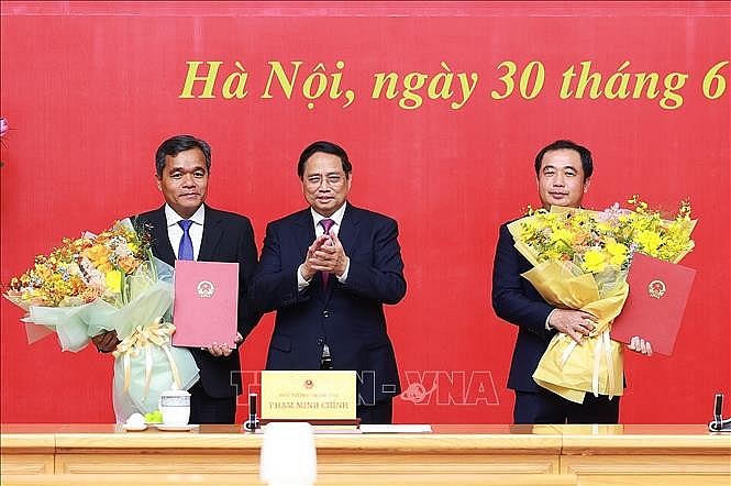 Thủ tướng Phạm Minh Chính trao quyết định và tặng hoa chúc mừng đồng chí Trần Đức Thắng, Phó Tổng Thanh tra Thường trực Thanh tra Chính phủ và đồng chí Hồ Văn Niên, Thứ trưởng Thường trực Bộ Dân tộc và Tôn giáo. Ảnh:TTXVN